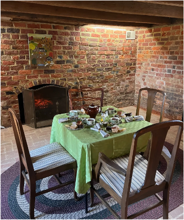 Cozy table by fireplace set for tea for four people at Terre Haute Farm and Retreat Center, Virginia